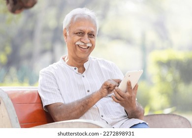 Happy senior men using digital tablet at park - Powered by Shutterstock