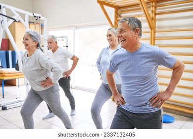 Happy senior men and women exercising with hands on hips during exercise class at rehabilitation center - Powered by Shutterstock