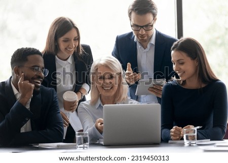 Group of happy diverse friends hugging on beach