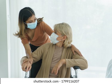 Happy Senior Mother And Daughter Wearing Protective Mask, Having Fun At Home.  Family Of Diverse Skin. Concept Of Love Sharing Time Care For Grandmother, Mother, Daughter, Granddaughter, And Adoption