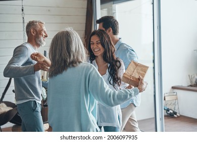 Happy Senior Parents Meeting Young Couple Inside The House