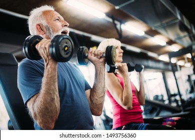 Happy Senior People Doing Exercises In Gym To Stay Fit