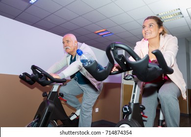 Happy Senior People Group Exercising In Spinning Class In Gym