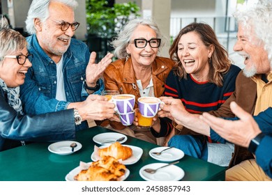 Happy senior people having breakfast sitting at cafe bar - Group of older friends having lunch at restaurant table - Food and beverage life style concept - Powered by Shutterstock