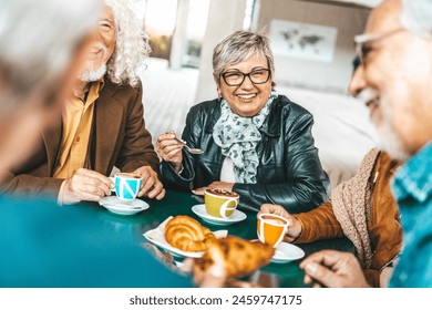 Happy senior people having breakfast sitting at cafe bar - Group of older friends having lunch in terrace restaurant - Food and beverage life style concept - Powered by Shutterstock