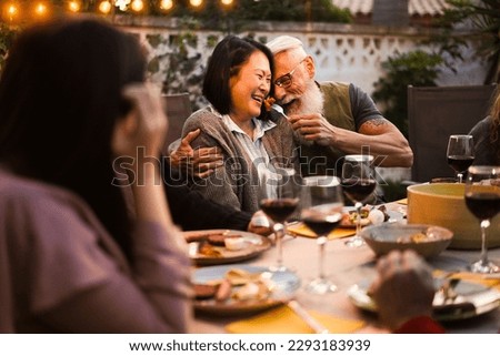 Happy senior people having fun at barbecue dinner - Focus on senior man hands