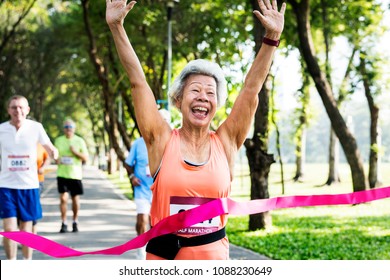 Happy senior running through the finish line - Powered by Shutterstock