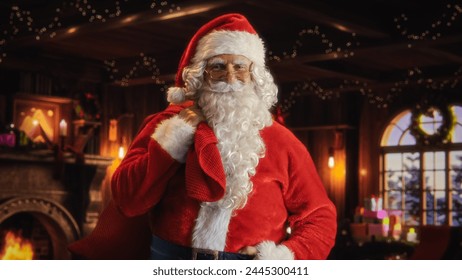 Happy Senior Santa Claus Looking at Camera and Posing at Festive Decorated Home, Holding a Big Red Bag with Gifts for Children. Santa Winks. Christmas, New Year, Holiday Celebration - Powered by Shutterstock