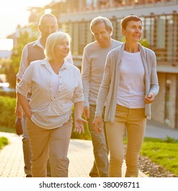 Happy Senior Travel Group Walking In A City In Summer