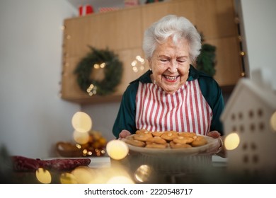 Happy senior woman baking Christmas cakes at home. - Powered by Shutterstock