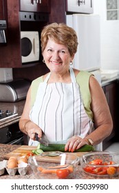 Happy Senior Woman Cooking In Kitchen