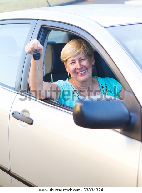 happy senior woman\
driver inside a car