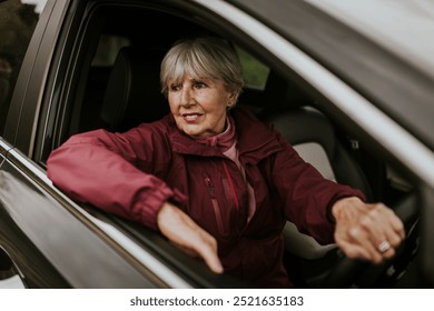 Happy senior woman driving car, travel photo. White old woman driving car on a trip. Senior Caucasian woman in a car lookin through car window. Happy senior woman driving, travel concept - Powered by Shutterstock