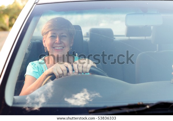happy senior woman driving a
car