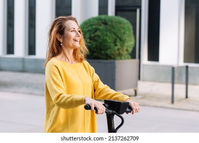 Happy Senior Woman With Electric Scooter In The City