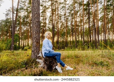 Happy senior woman enjoying nature having recreation with woods, sunset in summer forest outdoor. - Powered by Shutterstock