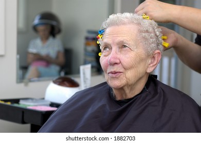 Happy senior woman getting her hair curled at a beauty salon. - Powered by Shutterstock