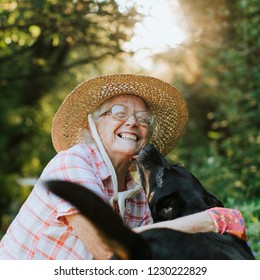 Happy senior woman getting kisses from her dog - Powered by Shutterstock