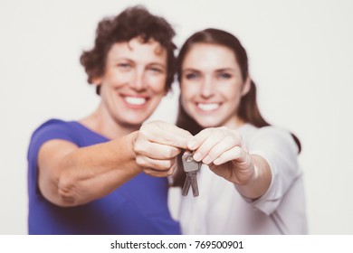 Happy senior woman and her daughter holding keys