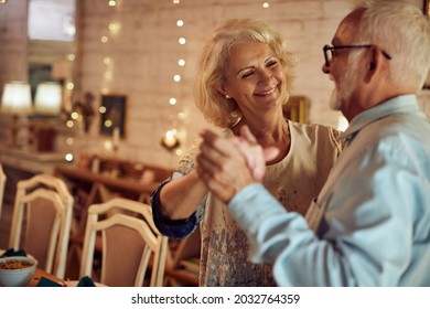 Happy senior woman and her husband dancing while celebrating Christmas at home. - Powered by Shutterstock