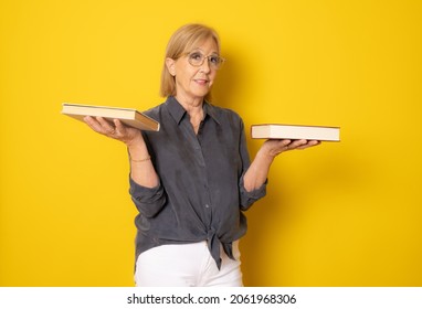 Happy senior woman holding books isolated over yellow background. - Shutterstock ID 2061968306