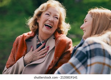 A Happy Senior Woman Laughing Outside With Granddaughter.