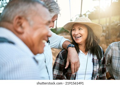 Happy Senior Woman In Nature With Friends While Taking An Outdoor Walk In Spring. Smiling Mature Woman Having A Conversation With A Man Outside. Old Smiling Lady Having Fun While Hiking With Aged