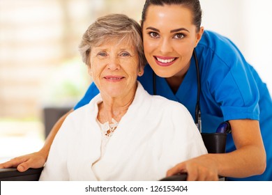 happy senior woman on wheelchair with caregiver