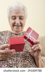 Happy Senior Woman Opening Gift