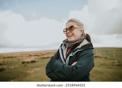 Happy senior woman outdoors portrait. Wellness for senior woman, hiking in nature at a cold beach. Tourist by the coast. Happy senior woman in sunglasses in winter. Winter in UK. - Powered by Shutterstock