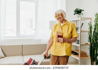 Happy senior woman with passport and travel ticket packed a red suitcase, vacation and health care. - Powered by Shutterstock