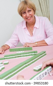Happy Senior Woman Playing Mahjong Game