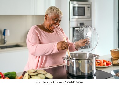 Happy Senior Woman Preparing Lunch In Modern Kitchen - Hispanic Mother Cooking For The Family At Home