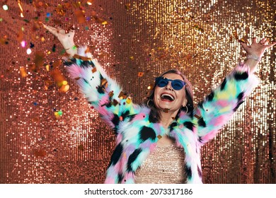 Happy Senior Woman Raising Hands Up While Having Fun Under Confetti Against Glitter Background