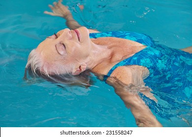 Happy senior woman relaxing in swimming pool with water yoga - Powered by Shutterstock
