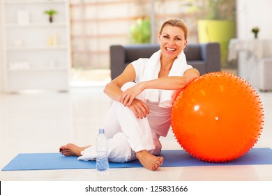 happy senior woman resting on mat after exercise at home - Powered by Shutterstock