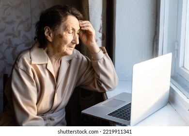 Happy Senior Woman Sitting With Her Granddaughter Looking At Laptop Making Video Call. Mature Lady Talking To Webcam, Doing Online Chat At Home During Self Isolation. Family Time During Corona