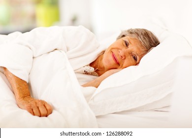 Happy Senior Woman Sleeping On Bed