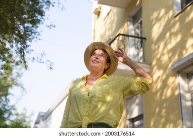Happy Senior Woman In Sun Hat Walks  On Summer City