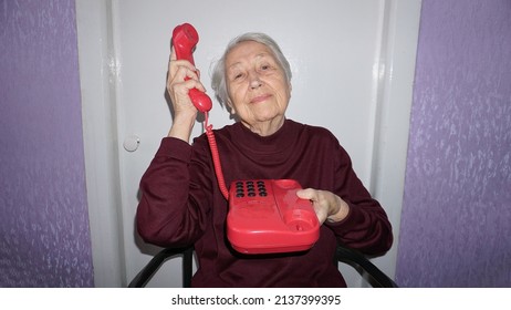 Happy Senior Woman Using Retro Style Landline Phone At Home