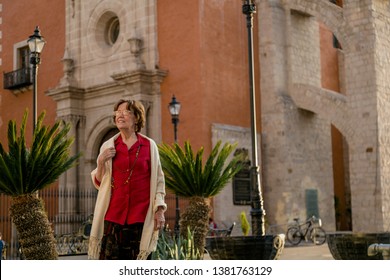 Happy Senior Woman Walking Around A Mexican Catholic Church Square. Plaza Fundadores, Durango, México.