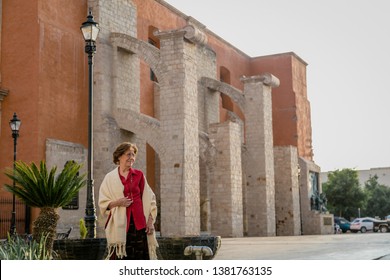 Happy Senior Woman Walking Around A Mexican Catholic Church Square. Plaza Fundadores, Durango, México.