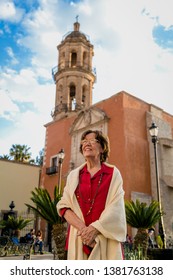 Happy Senior Woman Walking Around A Mexican Catholic Church Square. Plaza Fundadores, Durango, México.