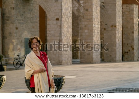 Happy senior woman walking around a mexican catholic church square. Plaza Fundadores, Durango, México.