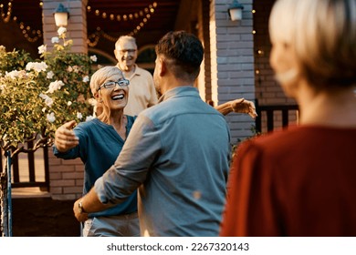 Happy senior woman welcoming her son and his wife in front of her home. - Powered by Shutterstock