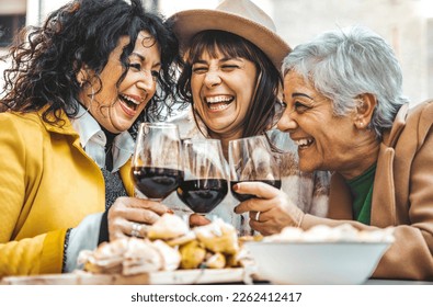 Happy senior women drinking red wine at bar restaurant - Mature people having fun hanging out on city street - Life style concept with older friends smiling and laughing together