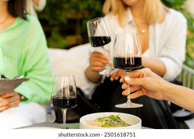 Happy senior women drinking wine and laughing together at restaurant - Powered by Shutterstock