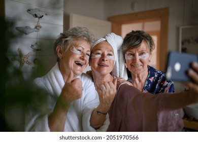 Happy Senior Women Friends In Bathrobes Taking Selfie Indoors At Home, Selfcare Concept.