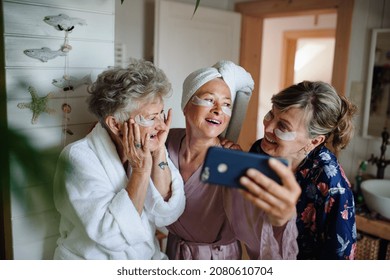 Happy Senior Women Friends In Bathrobes Taking Selfie Indoors At Home, Selfcare Concept.