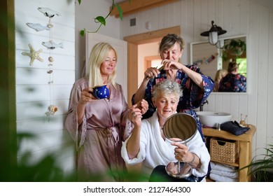 Happy Senior Women Friends In Bathrobes Having Fun Indoors In Bathroom, Selfcare Concept.